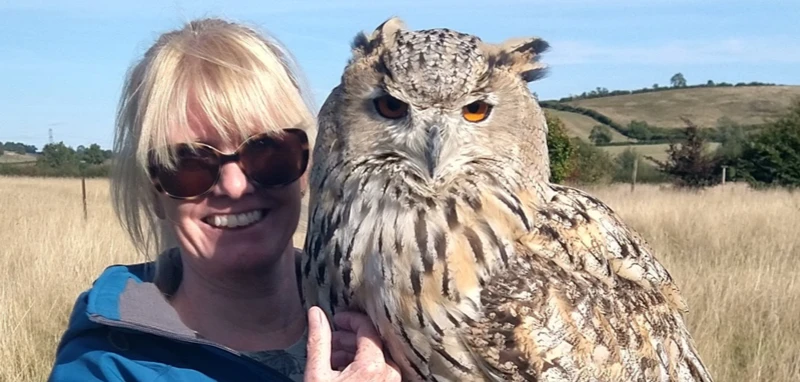 woman on an Meet The Owls experience holding a Siberian eagle owl